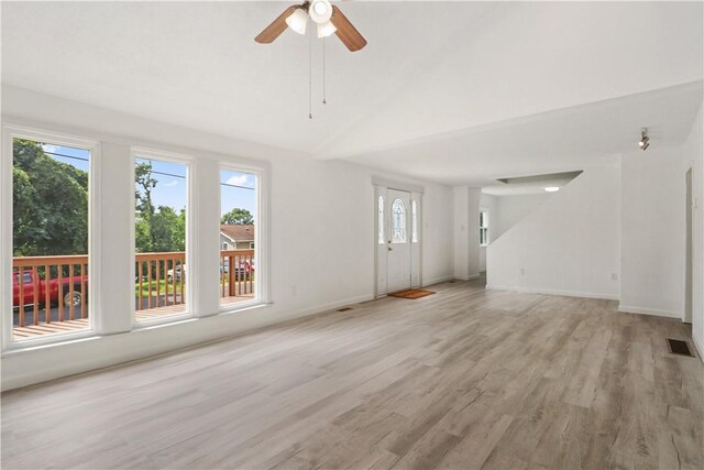 interior space with lofted ceiling, light hardwood / wood-style floors, a wealth of natural light, and ceiling fan