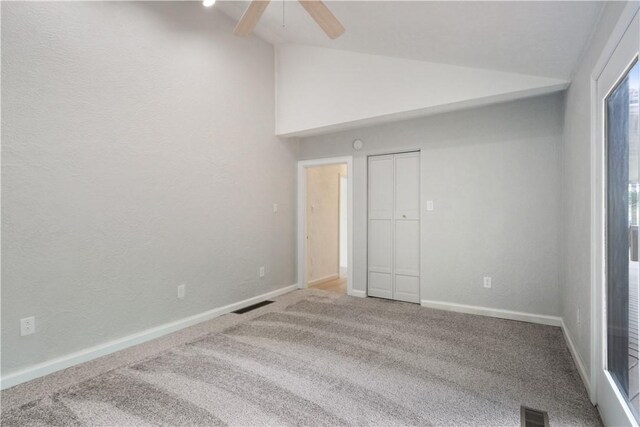 unfurnished bedroom with a closet, carpet floors, ceiling fan, and vaulted ceiling