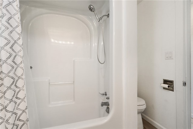 bathroom with shower / bath combo and toilet