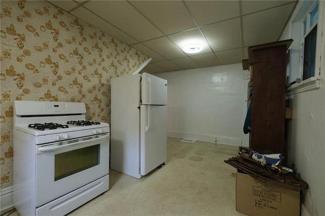 kitchen with light carpet, white appliances, and a drop ceiling