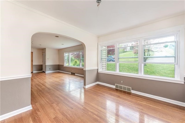 empty room with light hardwood / wood-style flooring and ornamental molding