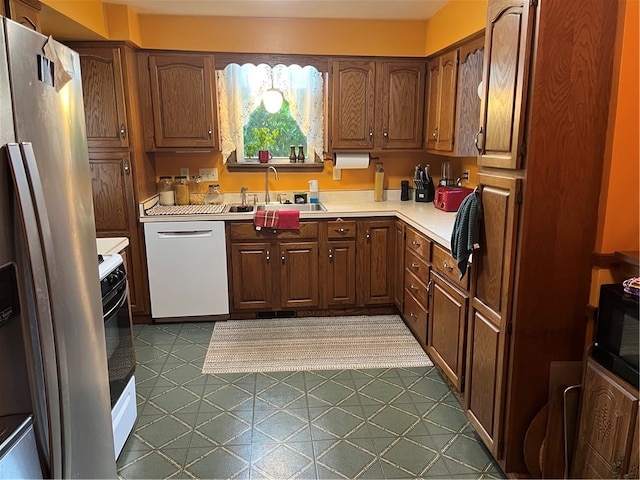 kitchen with tile patterned floors, sink, white dishwasher, and stainless steel refrigerator with ice dispenser