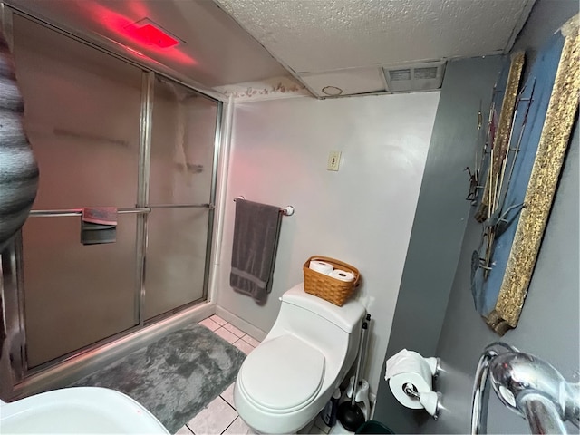 bathroom with a textured ceiling, toilet, and tile patterned floors