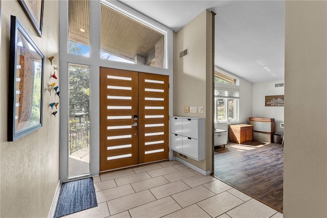 tiled entrance foyer with a healthy amount of sunlight, french doors, and vaulted ceiling