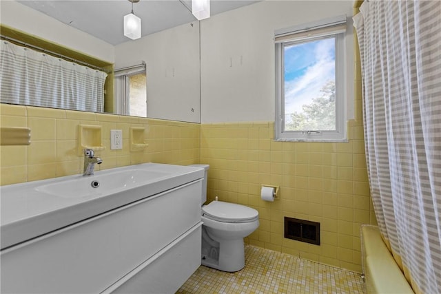 bathroom with tile patterned flooring, vanity, toilet, and tile walls