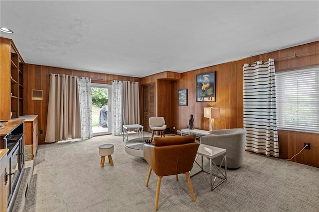 living room featuring wood walls and light carpet