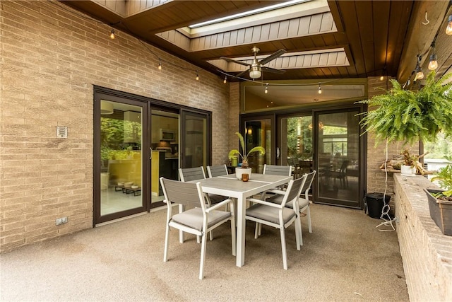 sunroom with a skylight, ceiling fan, and wood ceiling