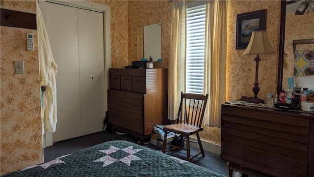 bedroom featuring dark colored carpet and wallpapered walls