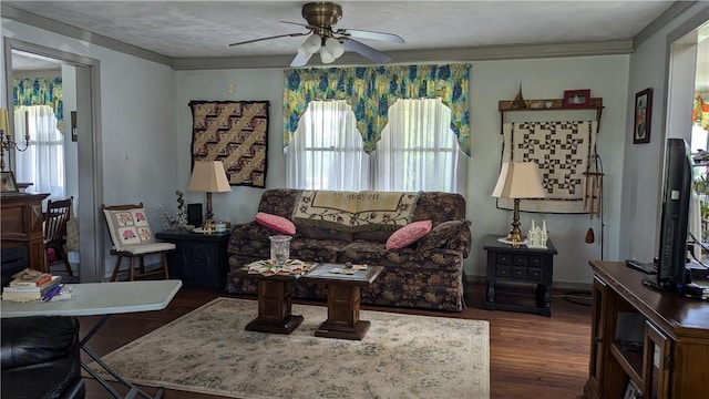 living area with ceiling fan, dark wood-style flooring, and crown molding