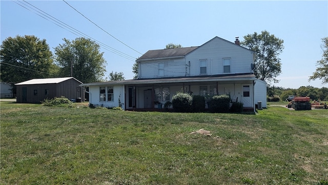 rear view of house featuring a yard