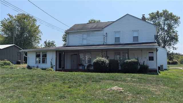 back of property with a yard and central AC