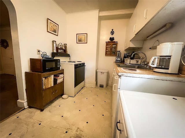 kitchen with light tile patterned flooring, sink, and white stove