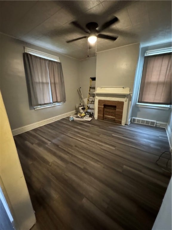 unfurnished living room with dark hardwood / wood-style floors and ceiling fan