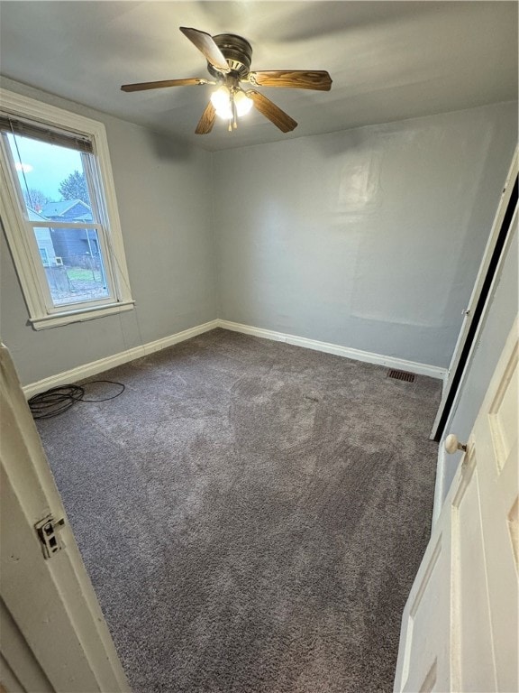 carpeted spare room with ceiling fan