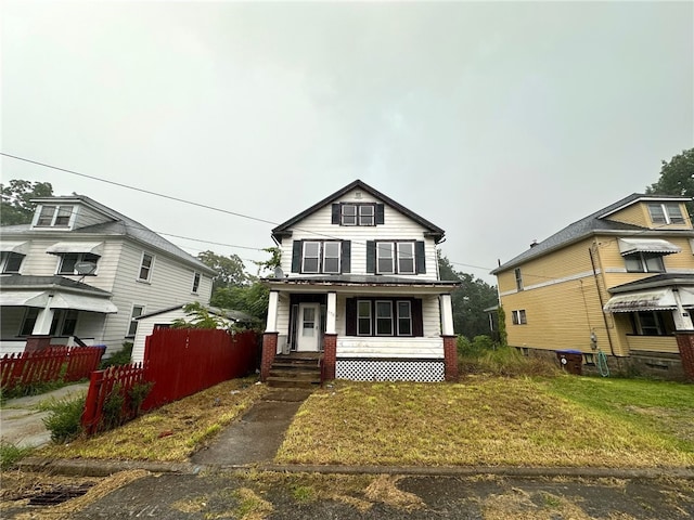 view of front of house featuring covered porch and a front lawn