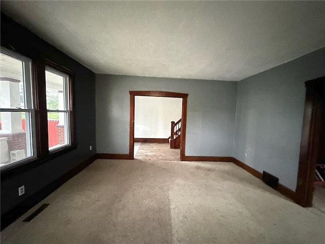 empty room featuring light colored carpet and a textured ceiling