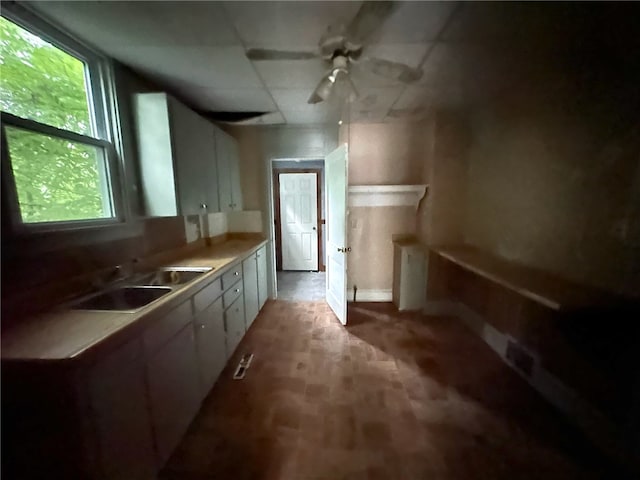 kitchen with sink, white cabinetry, and ceiling fan