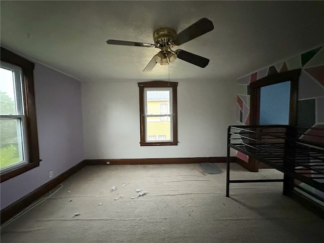 unfurnished bedroom with multiple windows and ceiling fan