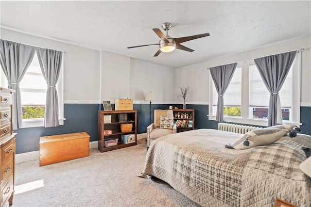 bedroom with baseboards, radiator, ceiling fan, and carpet flooring