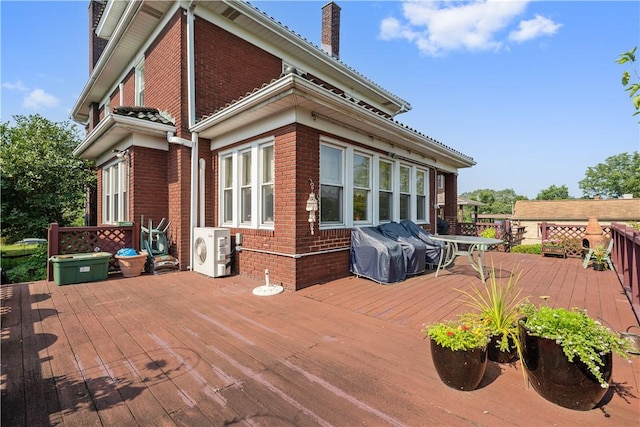 wooden deck with a grill and ac unit