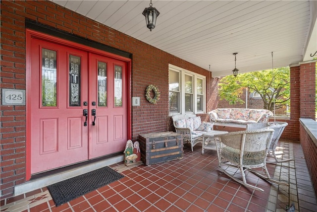 property entrance with brick siding and covered porch