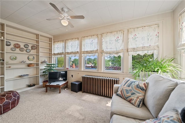 sunroom / solarium with radiator and a ceiling fan