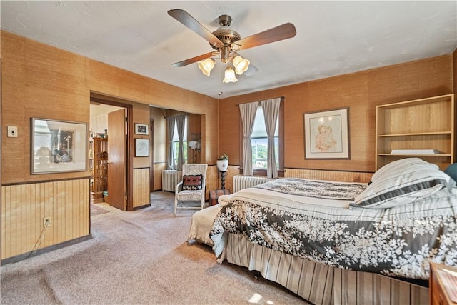 carpeted bedroom with radiator heating unit and a ceiling fan