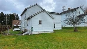 rear view of property featuring a yard