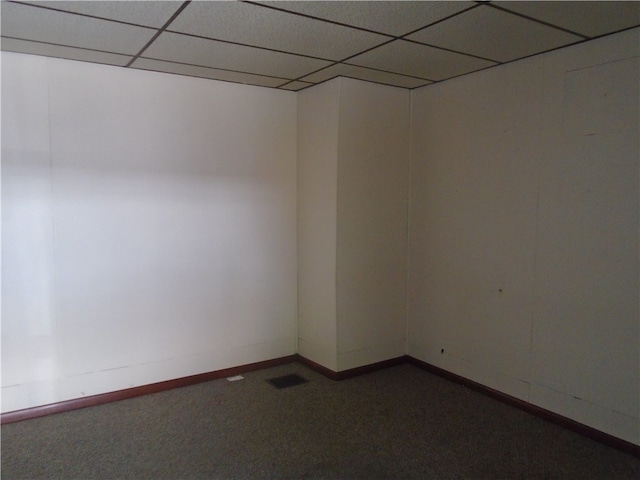 empty room featuring carpet and a drop ceiling