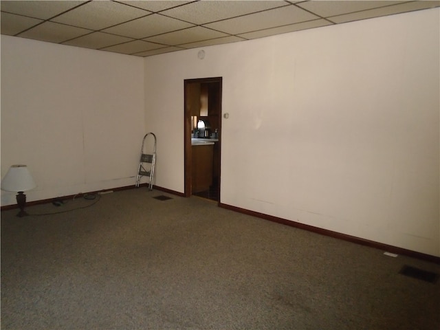 carpeted empty room with a paneled ceiling