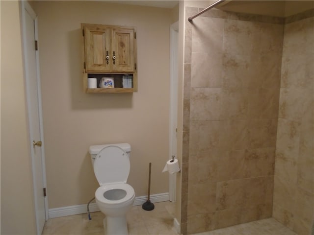 bathroom featuring tiled shower, tile patterned floors, and toilet