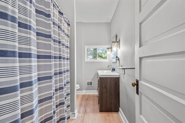 bathroom featuring vanity, hardwood / wood-style floors, and toilet