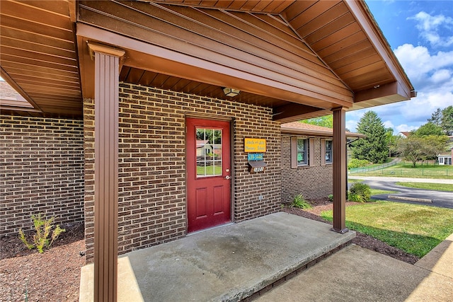 view of exterior entry with a lawn