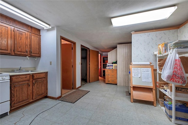 kitchen featuring brown cabinetry, light countertops, a sink, and light floors