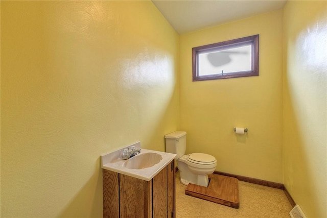 bathroom with visible vents, baseboards, vanity, and toilet