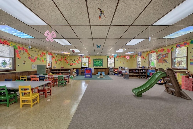 game room with a drop ceiling and plenty of natural light