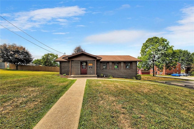 view of front of home featuring a front lawn, fence, and brick siding