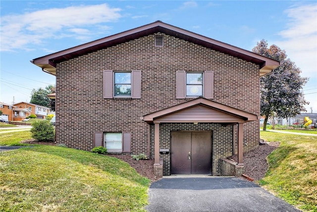 view of front of property with a front lawn and brick siding