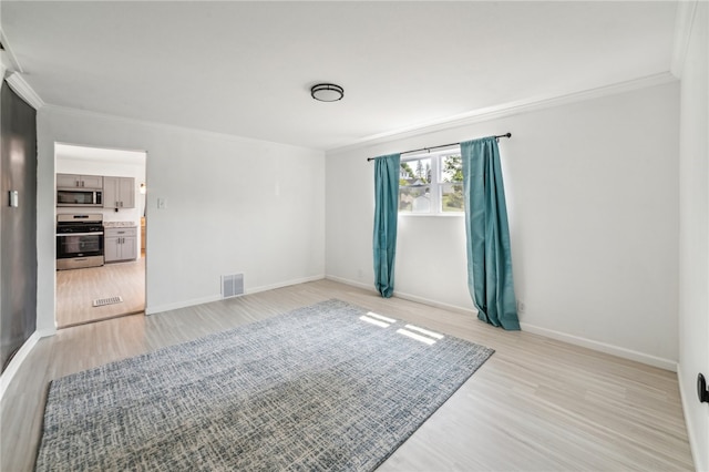 unfurnished room with light hardwood / wood-style floors and crown molding