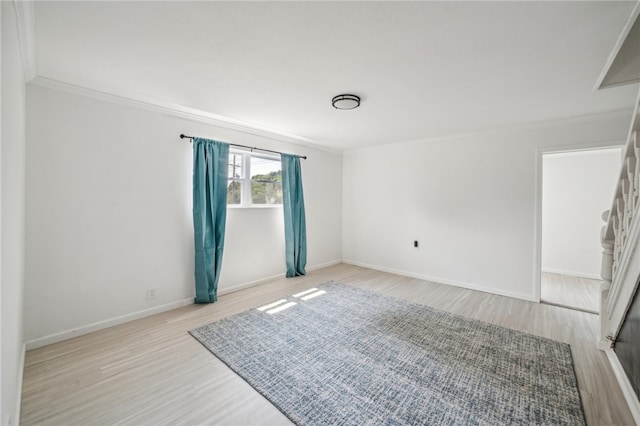 unfurnished room with crown molding and light wood-type flooring