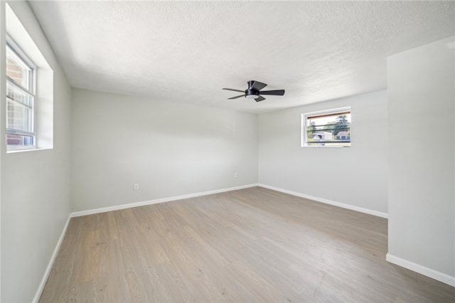 empty room featuring a textured ceiling, ceiling fan, and wood-type flooring