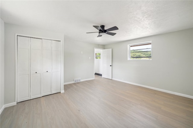 unfurnished bedroom with a closet, light wood-type flooring, and ceiling fan