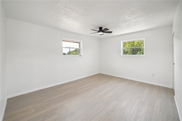 empty room featuring light hardwood / wood-style floors, ceiling fan, and plenty of natural light