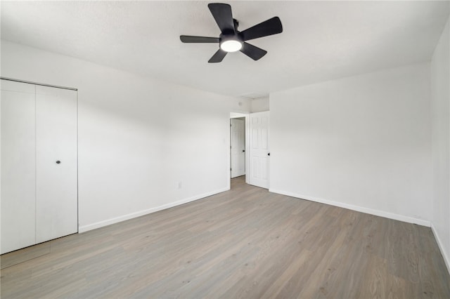 interior space with ceiling fan, wood-type flooring, and a closet