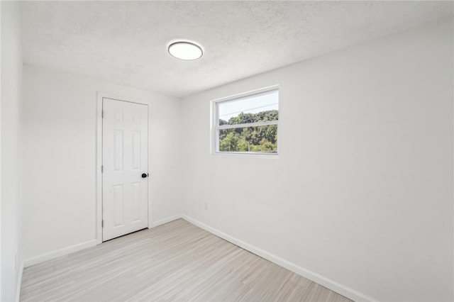 empty room featuring a textured ceiling and hardwood / wood-style floors