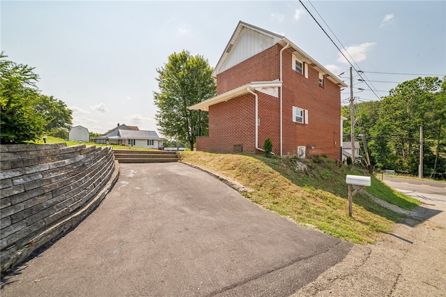 view of property exterior with a storage shed