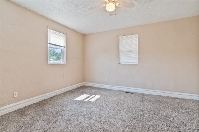 carpeted spare room featuring a textured ceiling and ceiling fan