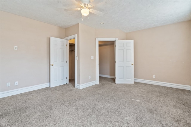 unfurnished bedroom with a textured ceiling, light colored carpet, a closet, and ceiling fan