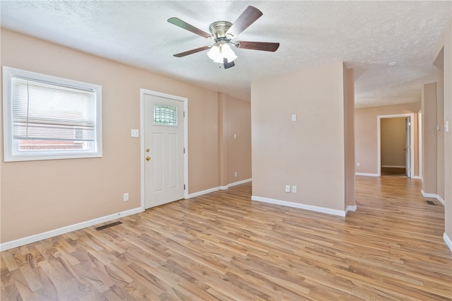 entryway featuring light hardwood / wood-style flooring, a textured ceiling, and ceiling fan