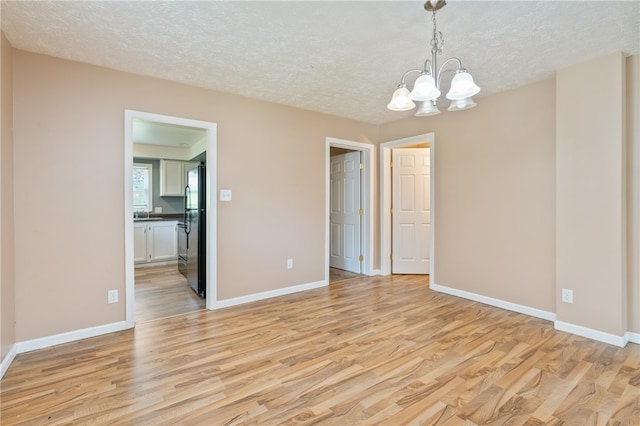 interior space featuring a chandelier, a textured ceiling, and light hardwood / wood-style flooring